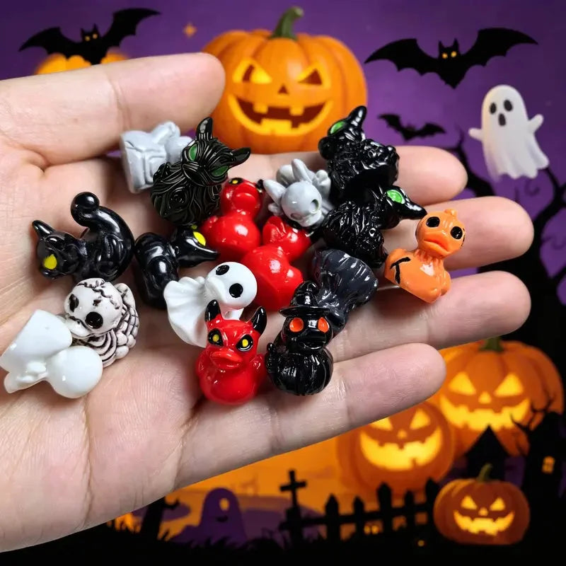 Assorted spooky ghost, skull, demon and witch resin duck figurines held in a hand
