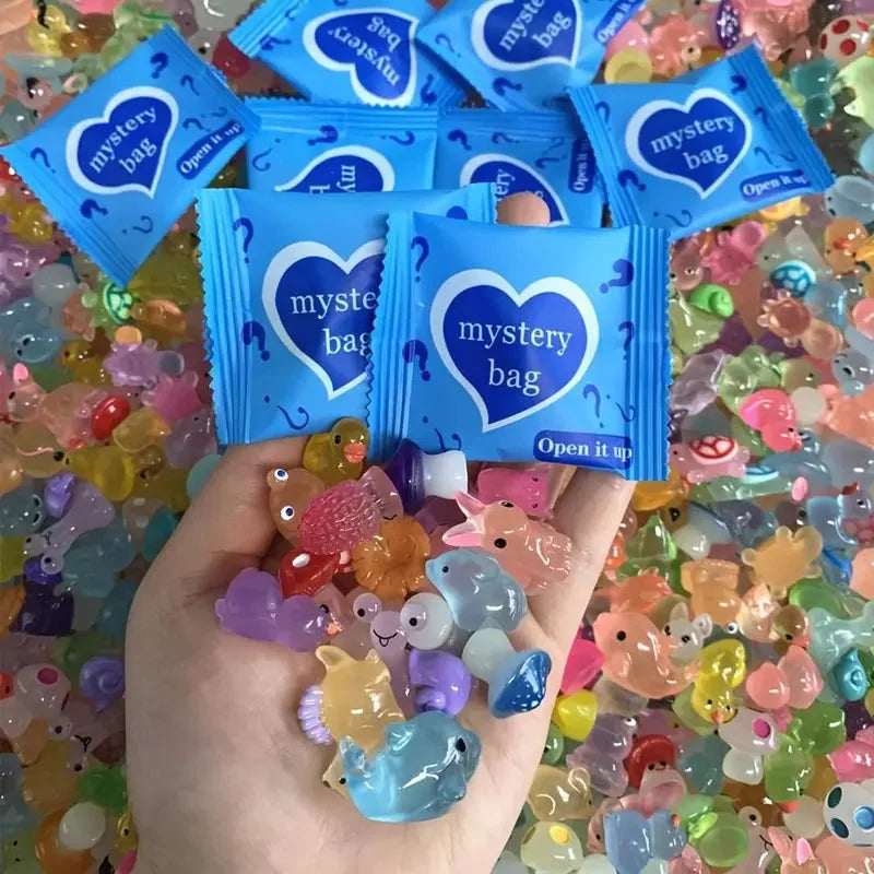 Two blue mystery bags with a handful of colorful mini resin animal figures