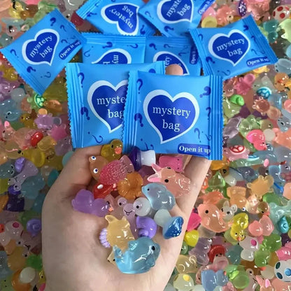 Two blue mystery bags with a handful of colorful mini resin animal figures