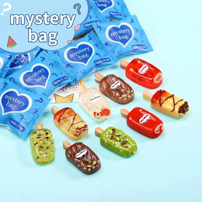 Chocolate, fruit and candy ice cream popsicle charms beside blue blind bags