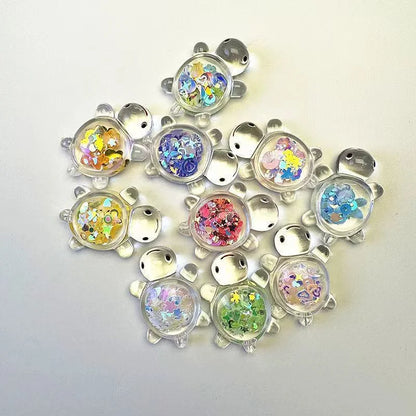 Assorted glitter turtle mystery bag figures arranged on a white background