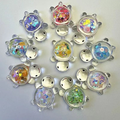 Colorful clear glitter turtle miniatures arranged in a circular display