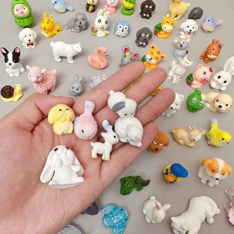 Hand holding small rabbit, cat and pet figures from an animal mystery bag