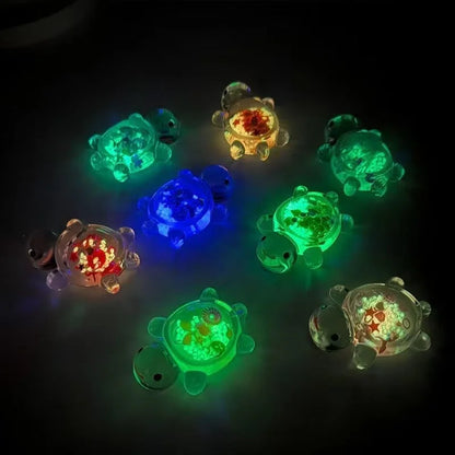Glitter turtle mystery bag figures glowing in blue, green and red in the dark