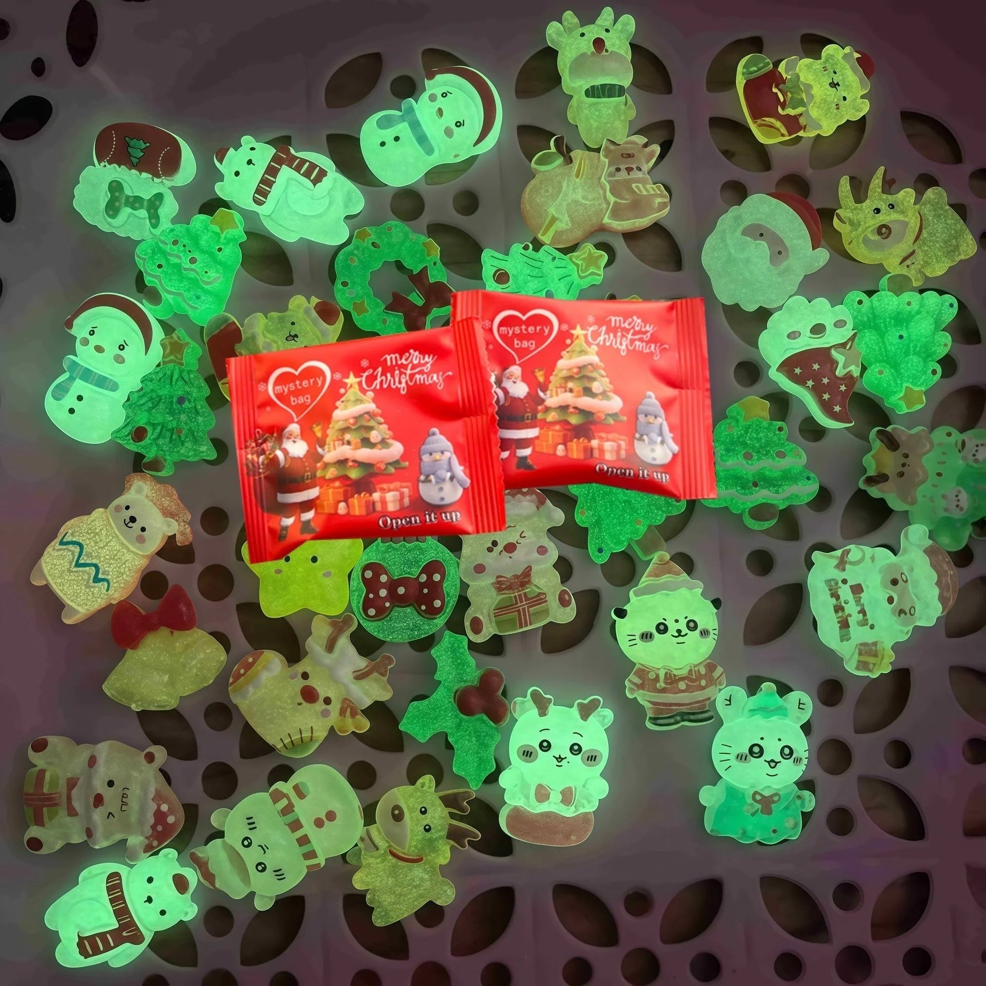 Christmas mini ornaments glowing green in the dark around red mystery bags