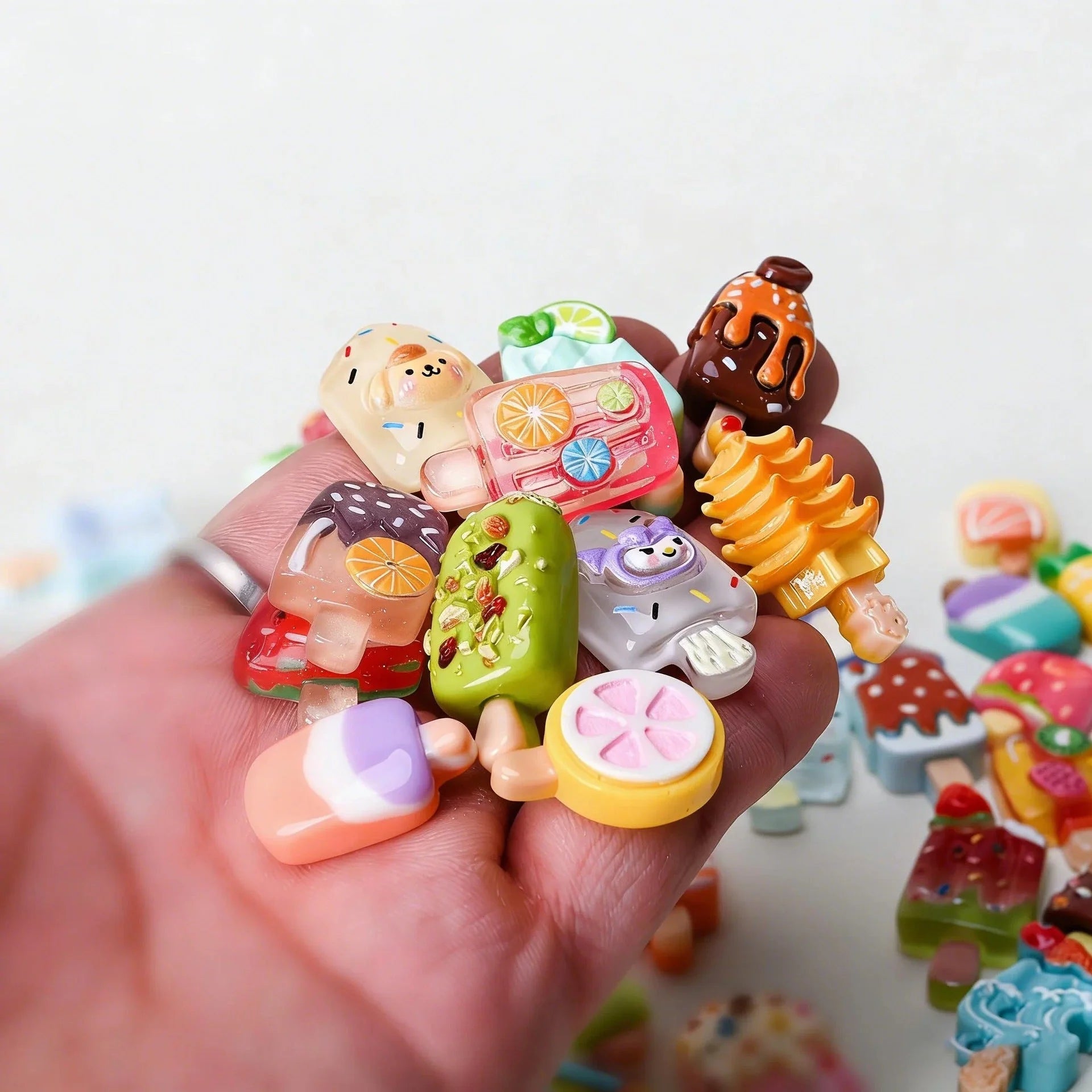 Hand holding assorted mini ice cream popsicle mystery bag charms